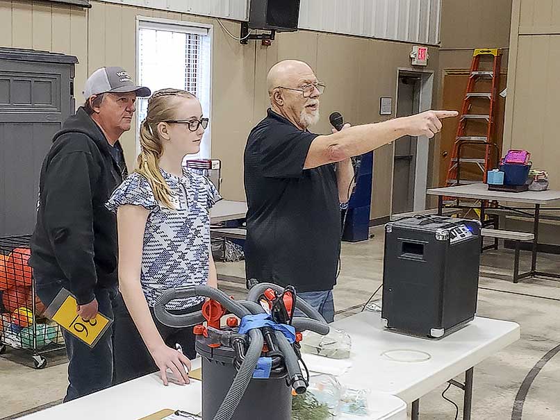 Long-term club member, Mike Hollingsworth,stepped in to help with auctioneering. Club treasurer, Cory Mohrhauser, and young Grace are ready to run items back to winning bidders.
